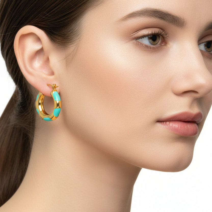 Gold hoop earrings with turquoise enamel on a white background