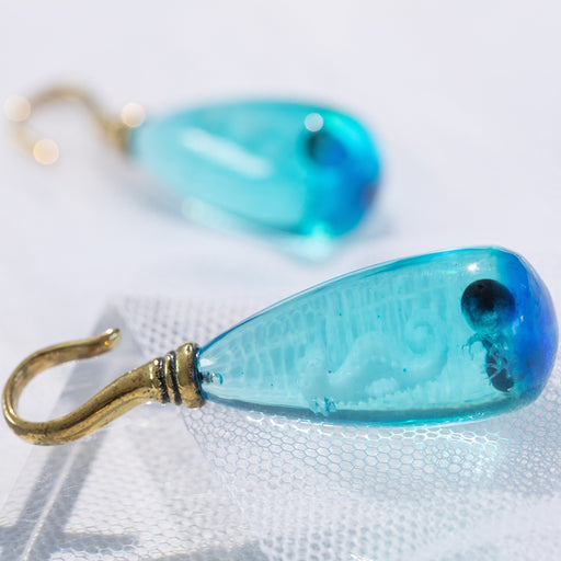 Sea Horse Epoxy Ear Hanger – Blue Epoxy Drop with White Seahorse and Black Pearl on Polished Brass Hanger with tulle background