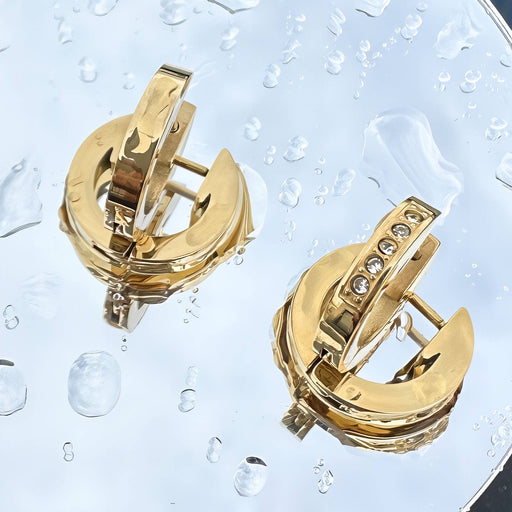 Gold earrings with a clear water droplet background