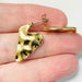 Gold heart-shaped earring on a hand with a white background