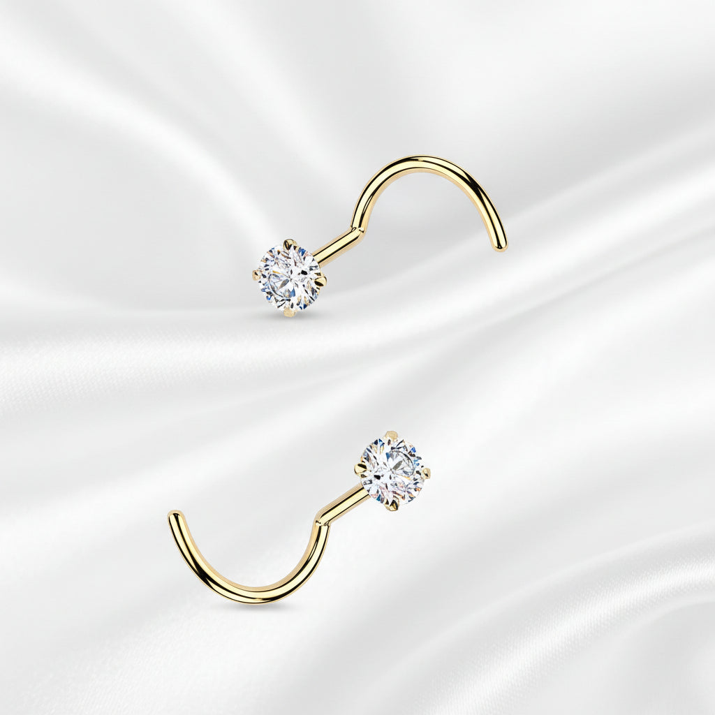 Set of gold and silver nose rings with clear gemstones on a white background