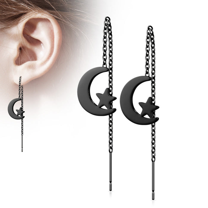 Black moon and star earrings with chains worn by a person.