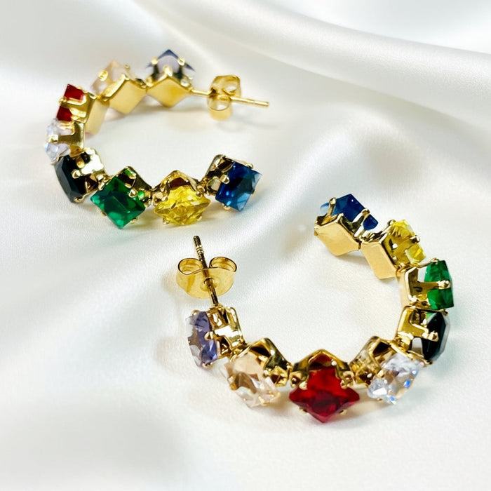 Colorful hoop earrings with gold setting on a light gray background